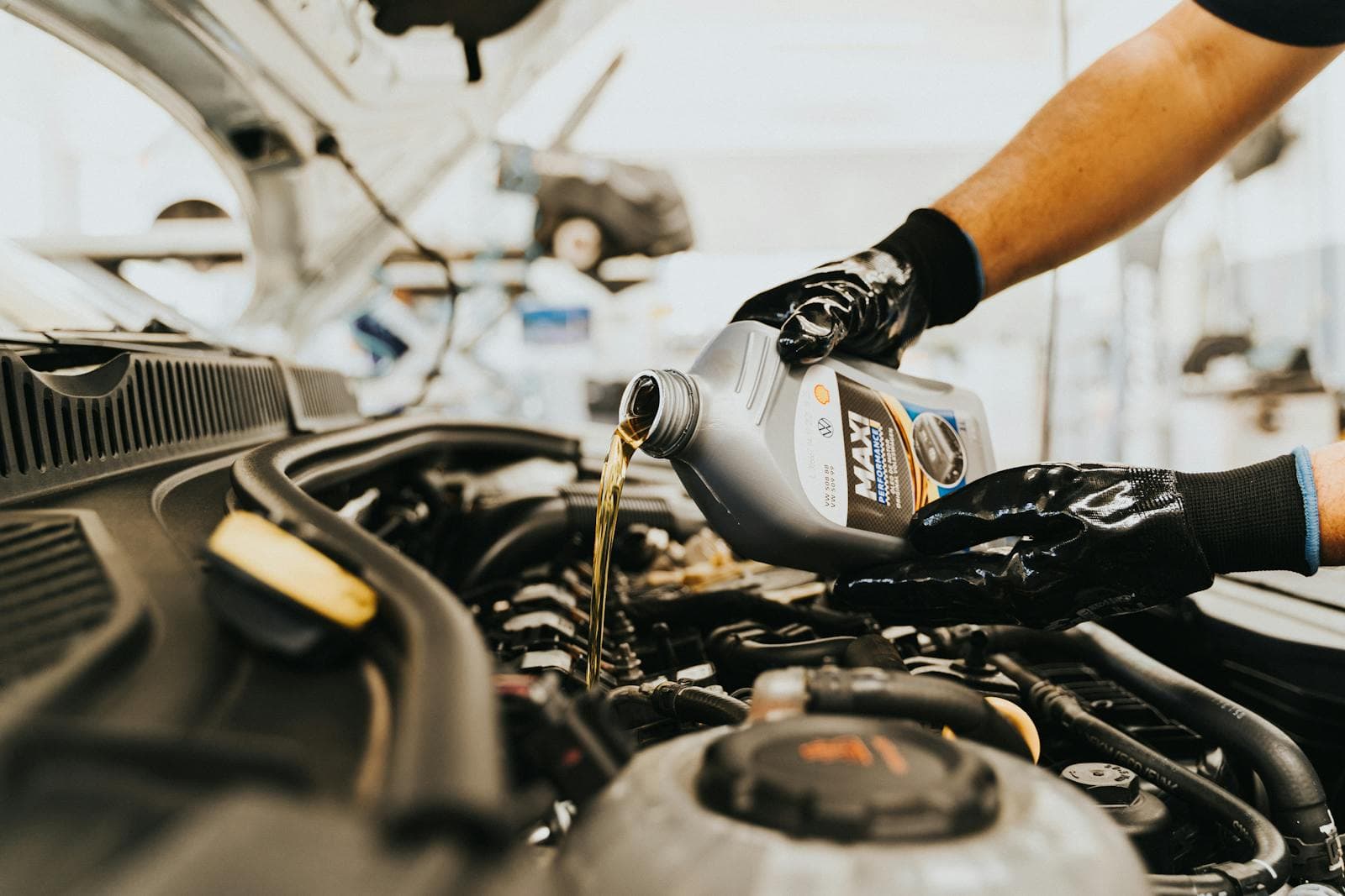 Technician holding a car battery in a workshop for inspection and fitting