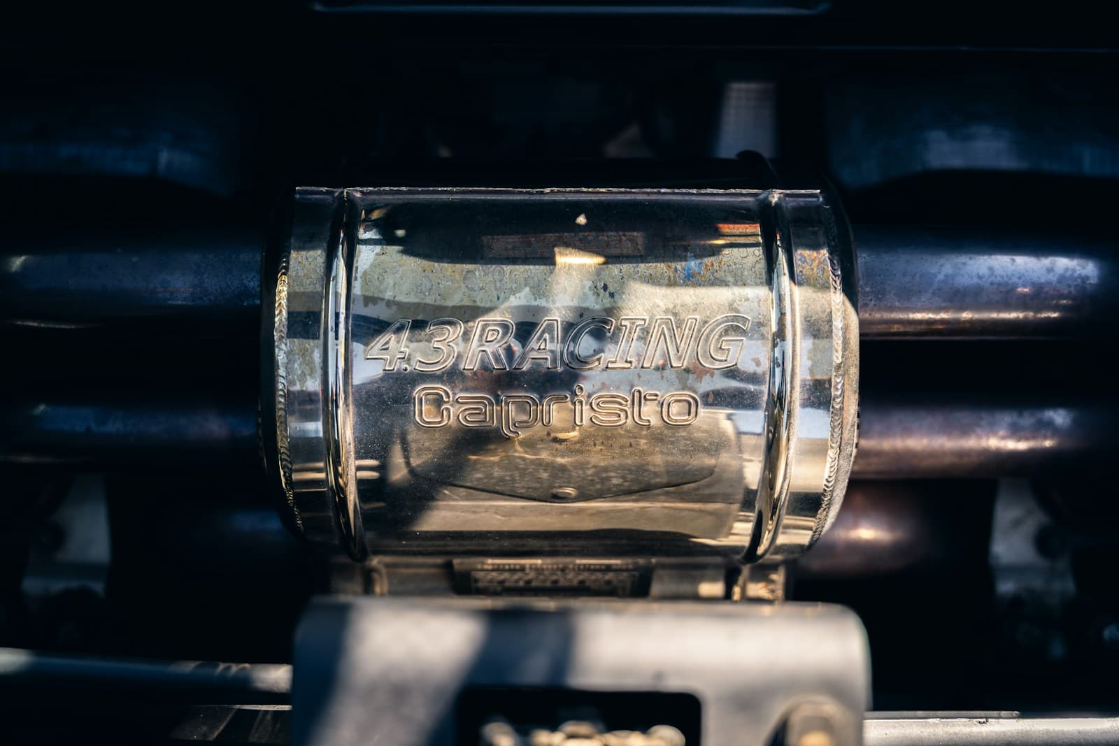 Racing-style exhaust clamp and joint hardware on a work surface